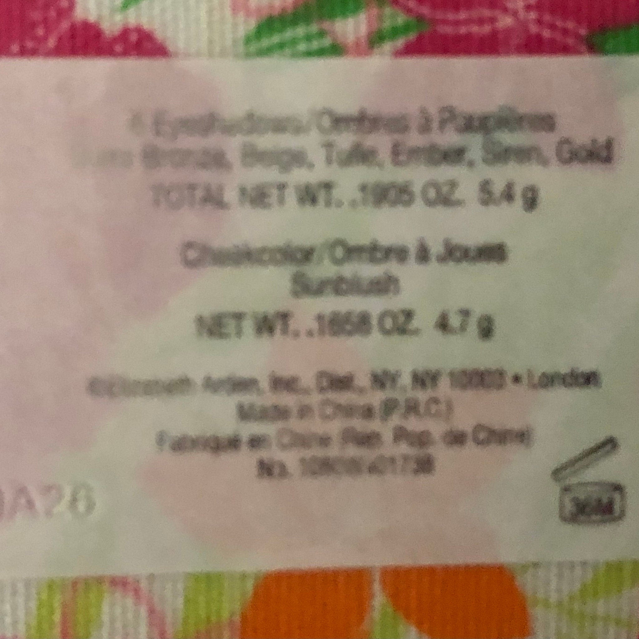 Cosmetics label with white background, black text, and colorful floral pattern at bottom