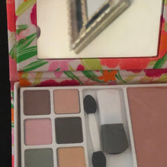 Eyeshadow palette with floral pattern, various color eyeshadows, and mirror for makeup application