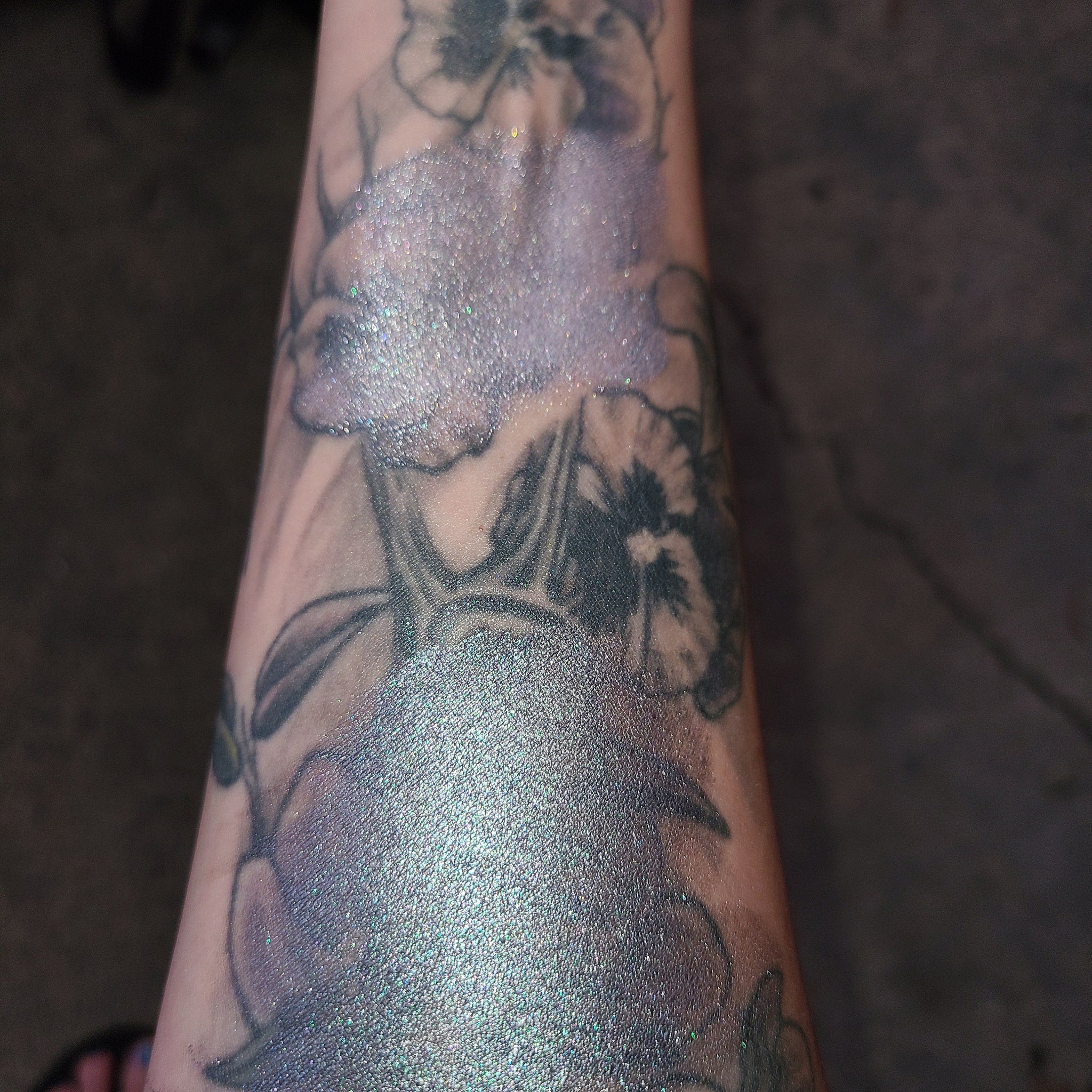 Side view of multichrome eyeshadow palette showing shifting iridescent hues in angled lighting