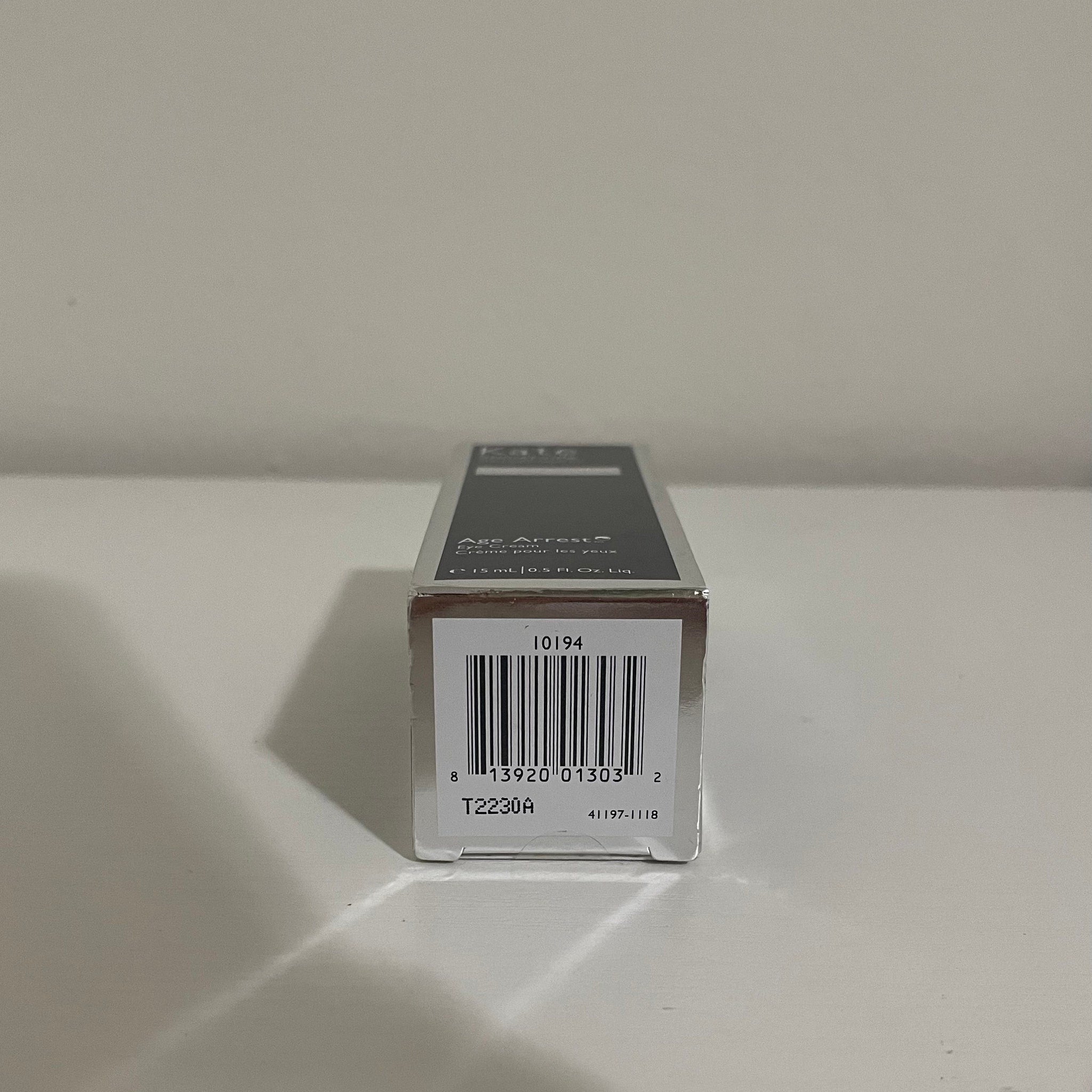 Eye cream box with silver and black text, barcode, and brand name Kate visible on packaging