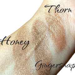 Close-up of taupe brown shimmer eyeshadow with luster finish in sifter jar, showcasing fine mineral texture
