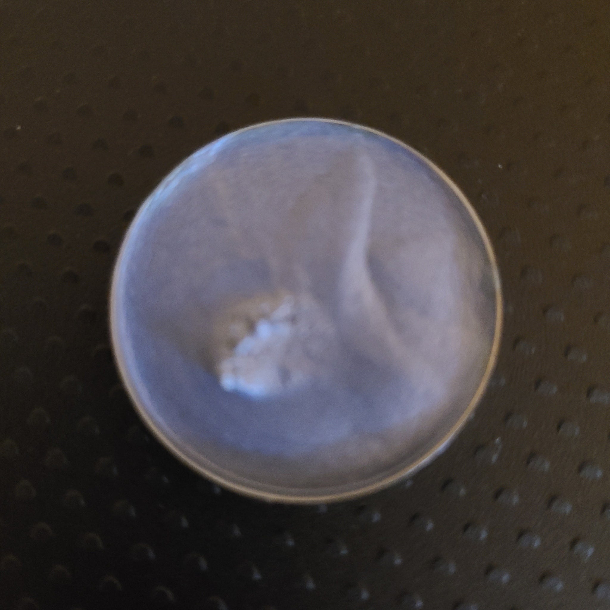 Close-up of creamy pastel blue eyeshadow with soft fluffy texture in compact palette