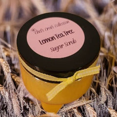 Sugar scrub jar with black lid, yellow ribbon, and "Lemon Tea Tree" label text