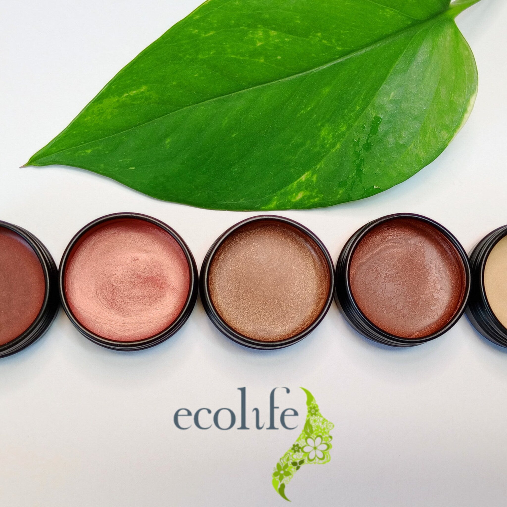 Lip balms in various shades, metallic finish, black containers, with Ecolife Cosmetics logo