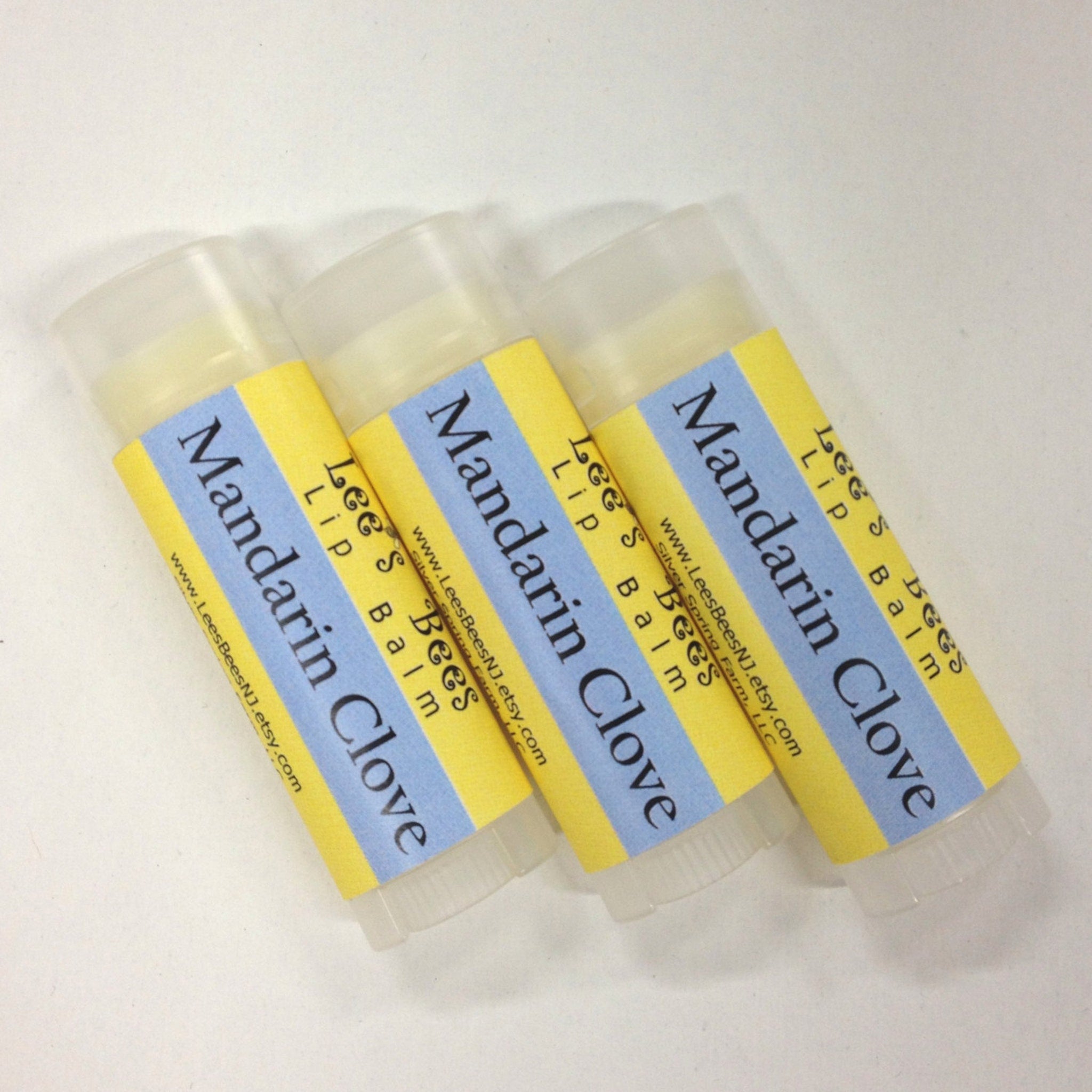 Lip balm tubes with yellow and blue labels, clear plastic container, Lees Bees brand
