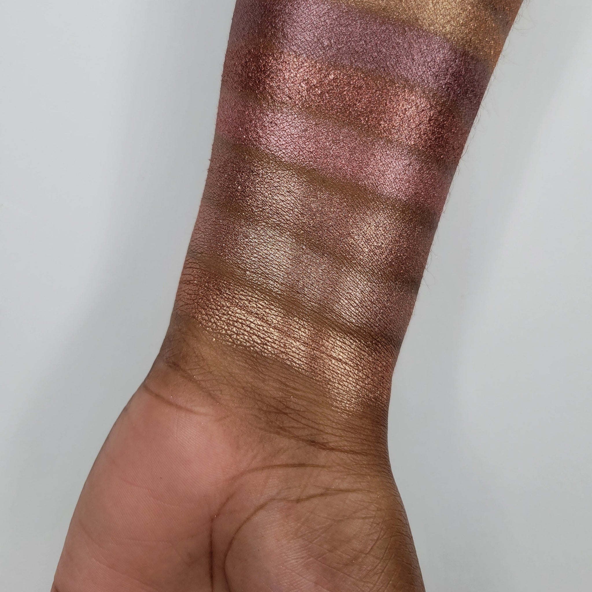 Side view of beige blush shimmer eyeshadow in round compact showing baked powder texture