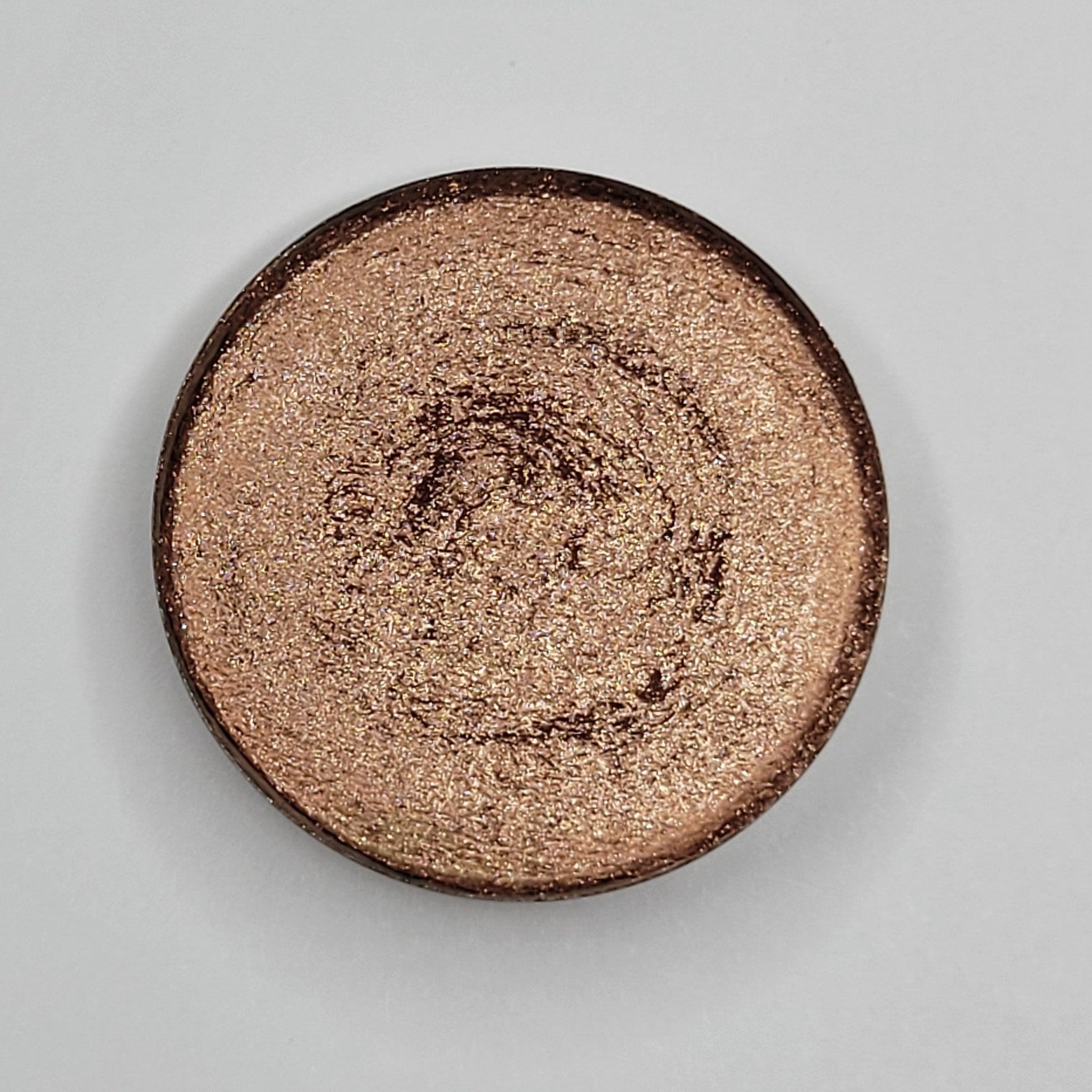 Close-up of Fresh Baked Shimmer Eyeshadow in Beige Blush showing soft pink-beige powder with golden shimmer particles