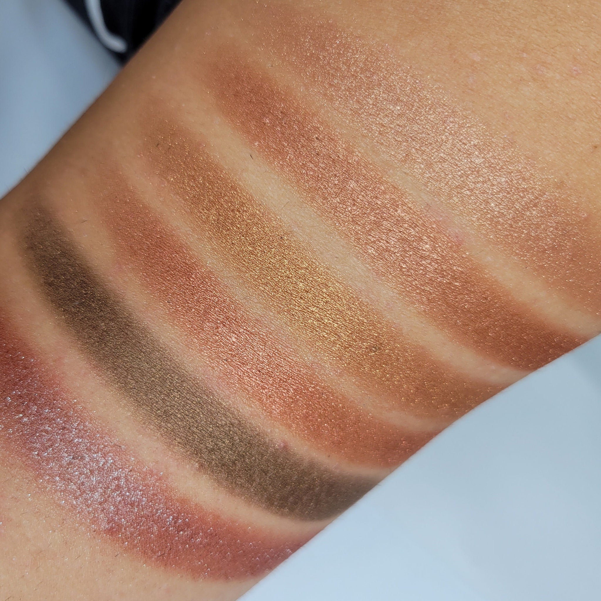 Close-up of cinnamon bronze shimmer eyeshadow pan showing rich metallic sparkle texture