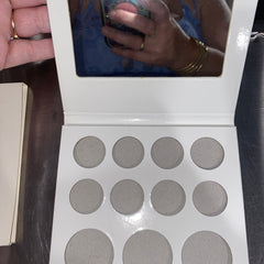 Side view of 11-pan eyeshadow palette showing mirror and gradient of matte to shimmer shades in warm neutrals