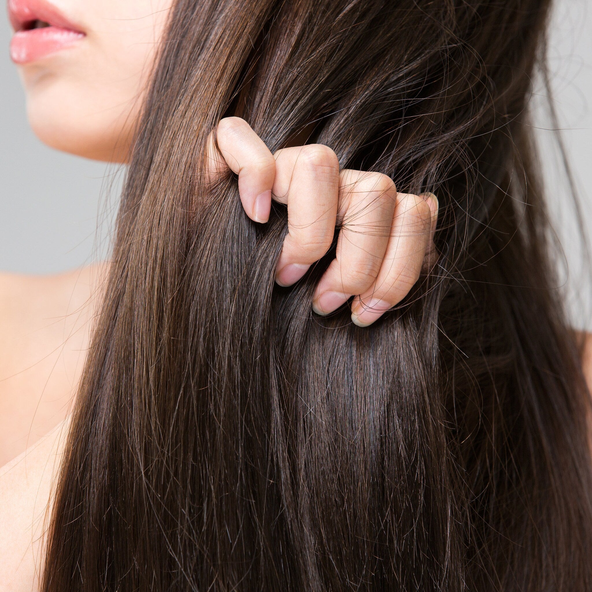Dark brown hair with hand, smooth texture, close-up view