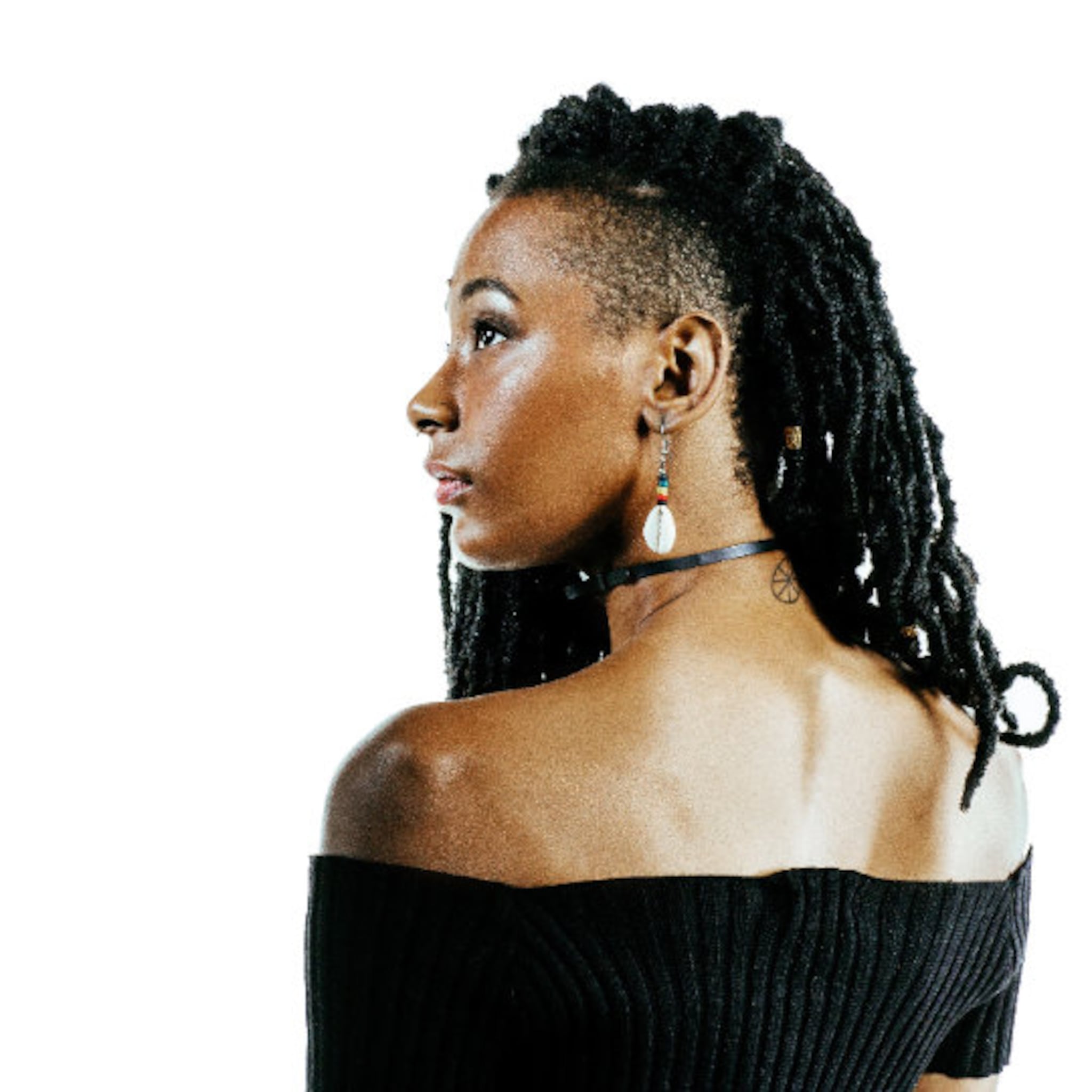 Woman with black dreadlocks and off-the-shoulder black ribbed top, wearing a choker and earrings