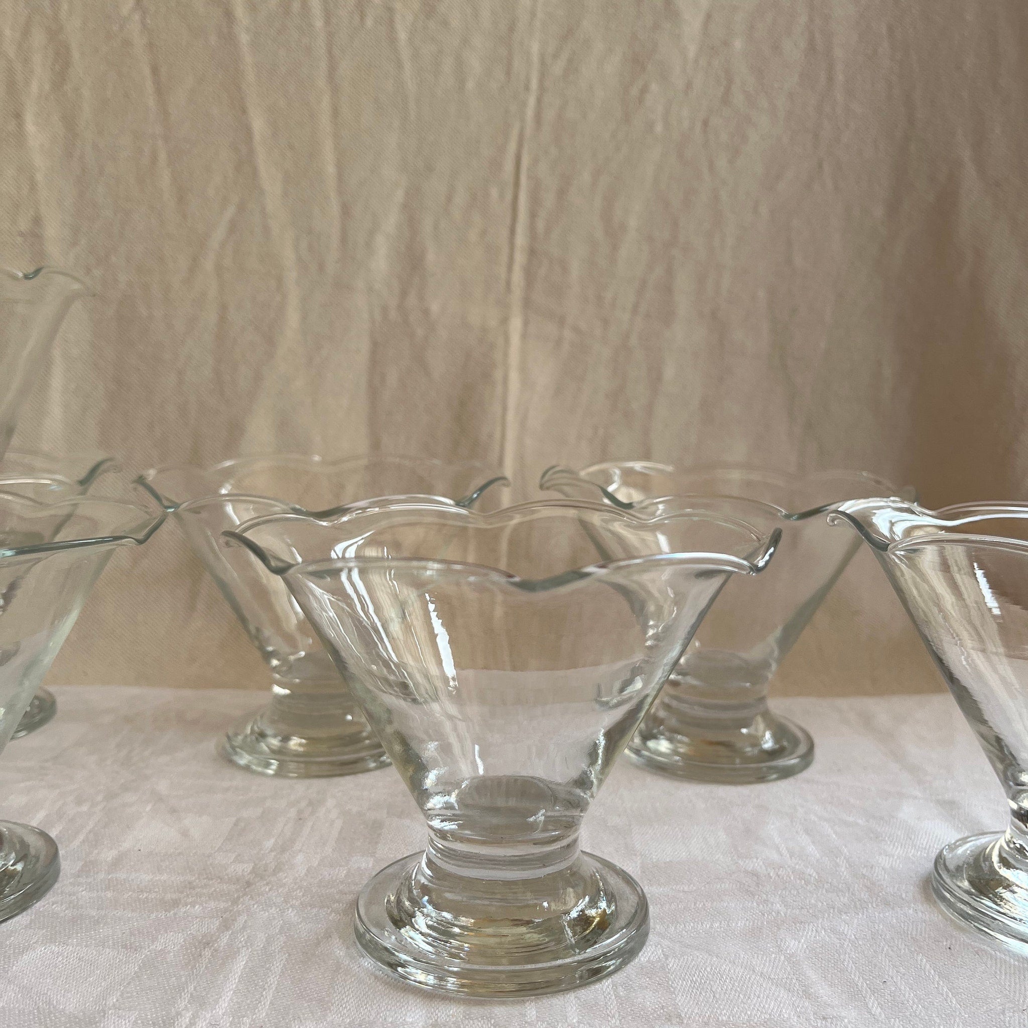 Glass dessert dishes with clear glass, scalloped rim, and pedestal base