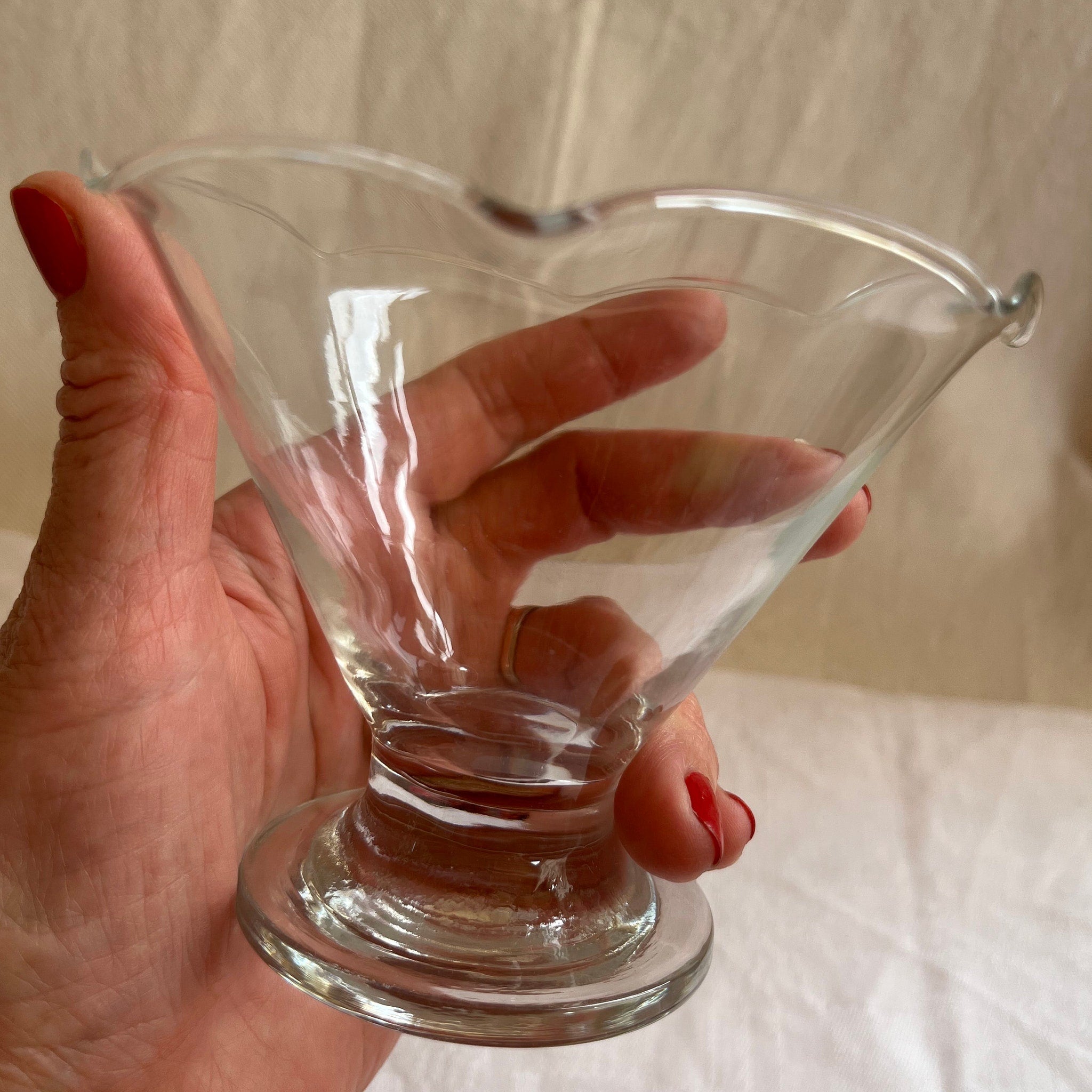 Sundae glass clear glass with flared bowl and pedestal base, held in hand