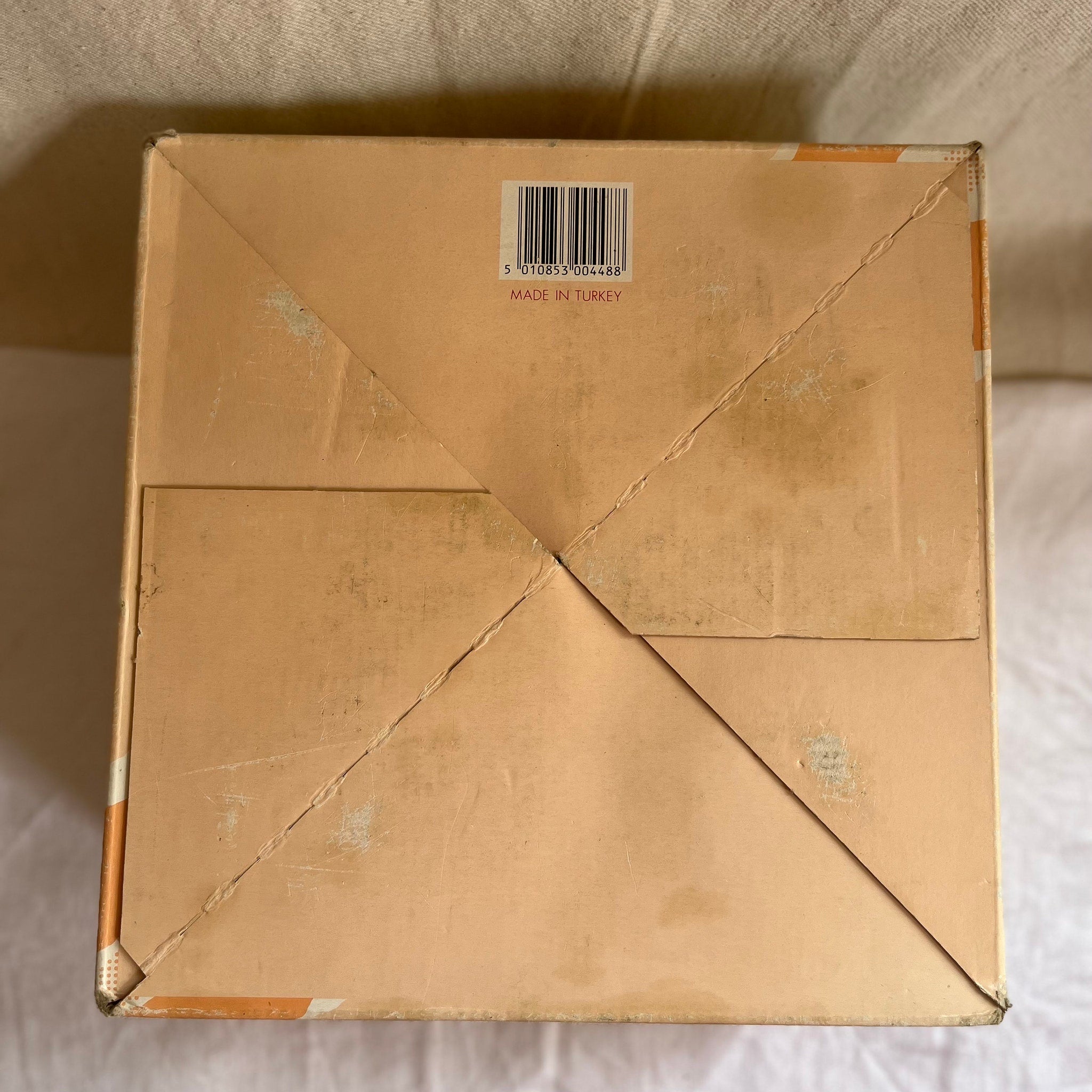 Cardboard box with tan color, folded construction, and "Made in Turkey" text visible on surface