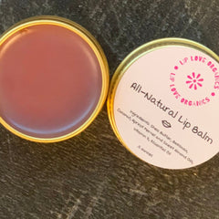 Lip balm with gold rim, pink and mauve color, and "Lip Love Organics" text label on lid