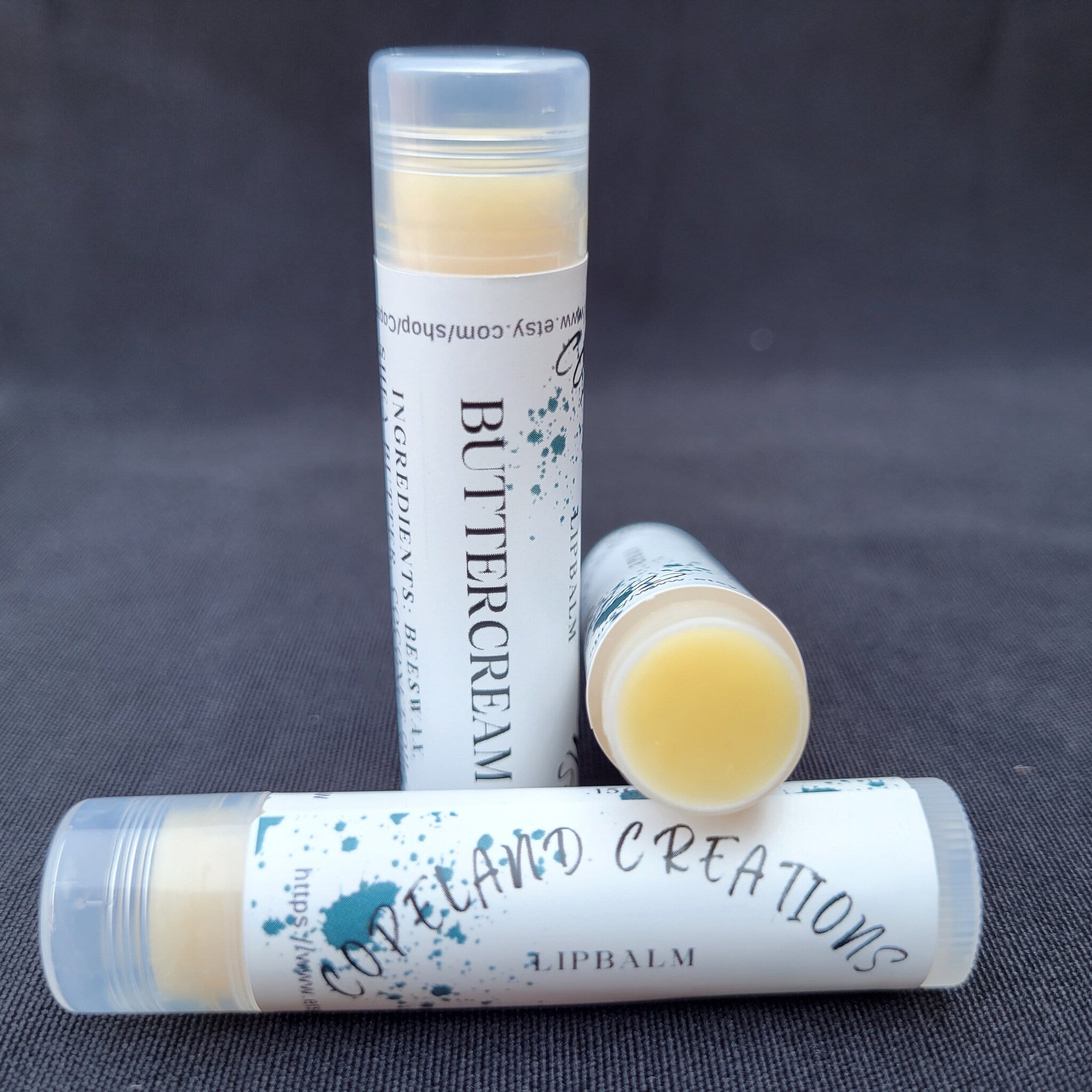Lip balm tubes with white labels, yellow balm, and clear caps, Copeland Creations brand