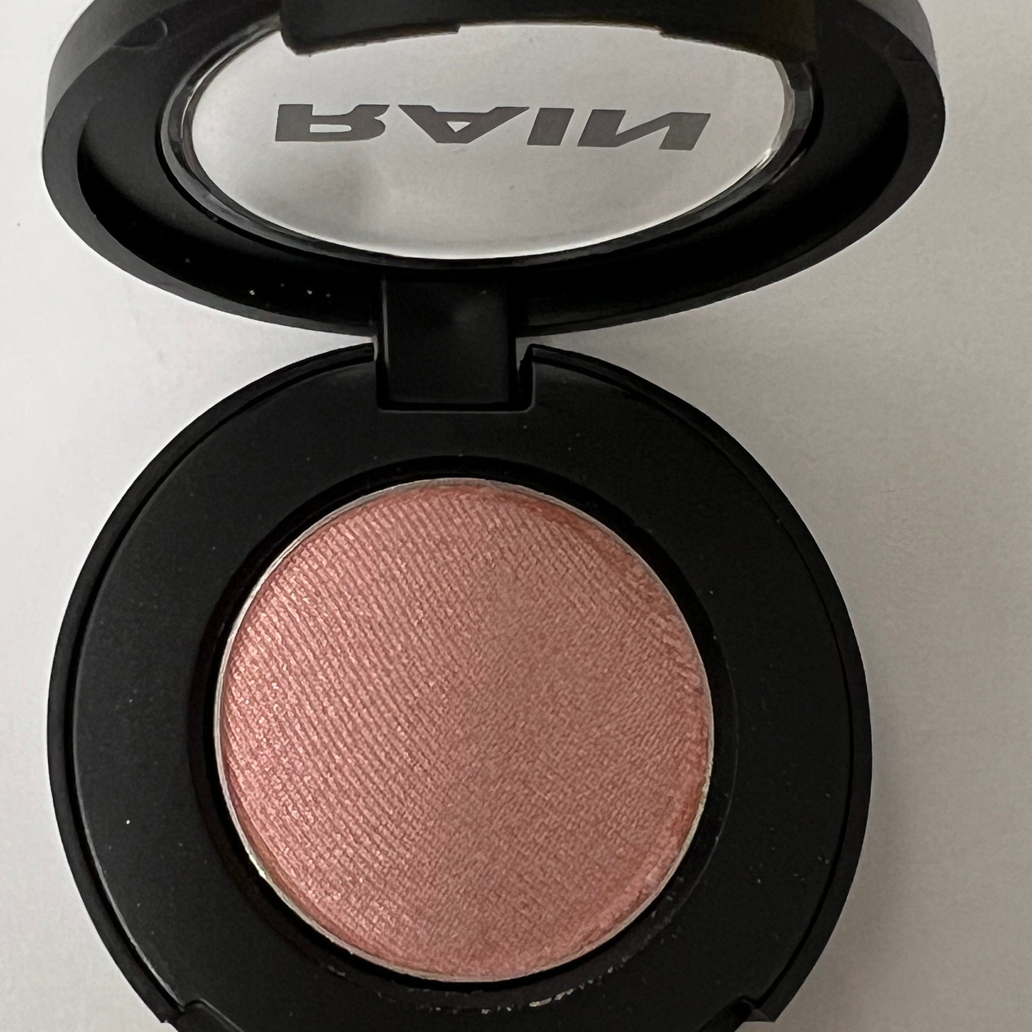Close-up of Shimmering Ice Baby Eye Shadow 211 showing frosted silver powder with reflective glitter particles