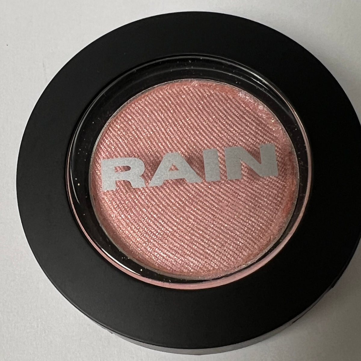 Close-up of Shimmering Ice Baby Eye Shadow 211 in a compact with frosty silver-blue shimmer and smooth pressed powder finish