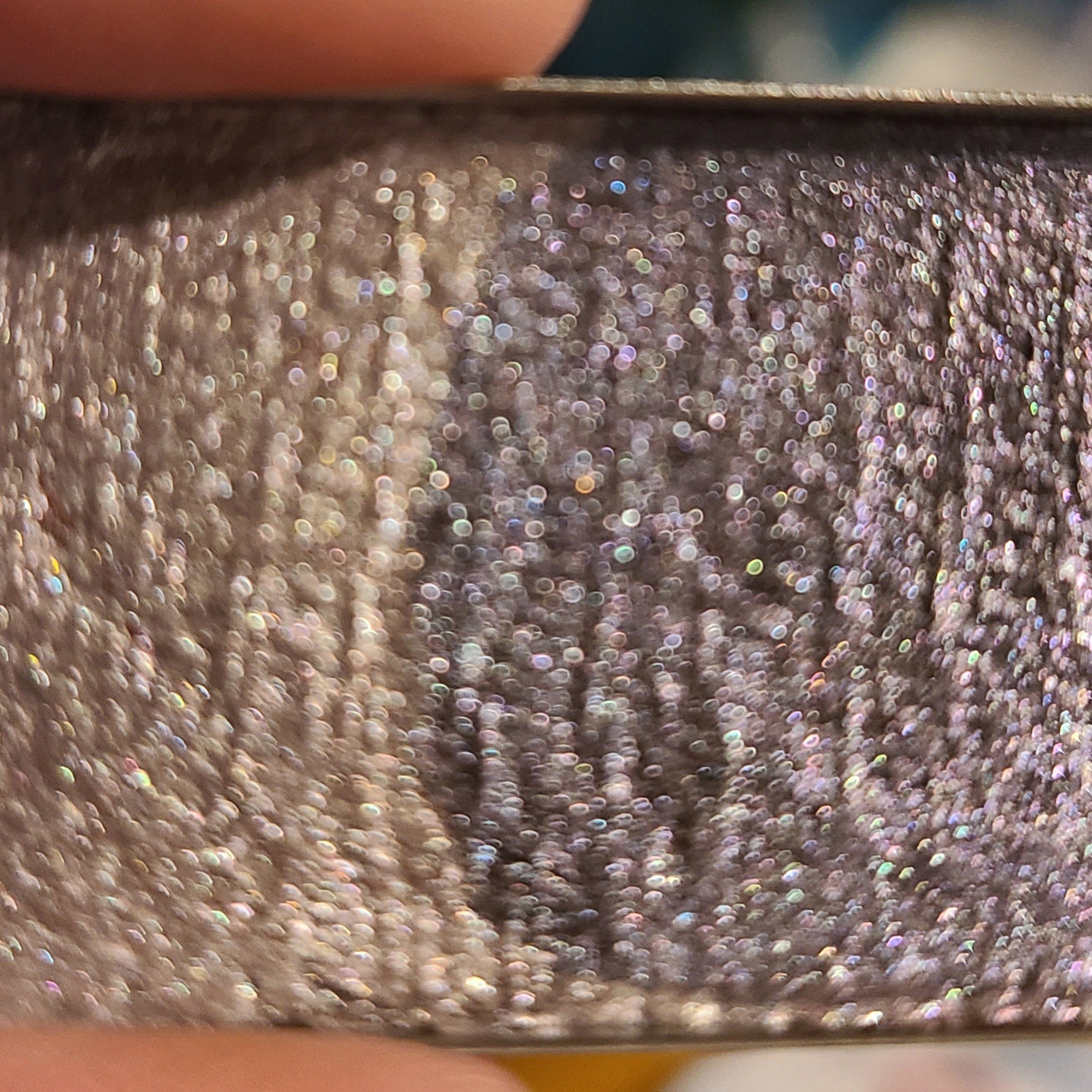Side view of multichrome eyeshadow palette showing iridescent shift from bronze to green in compact case