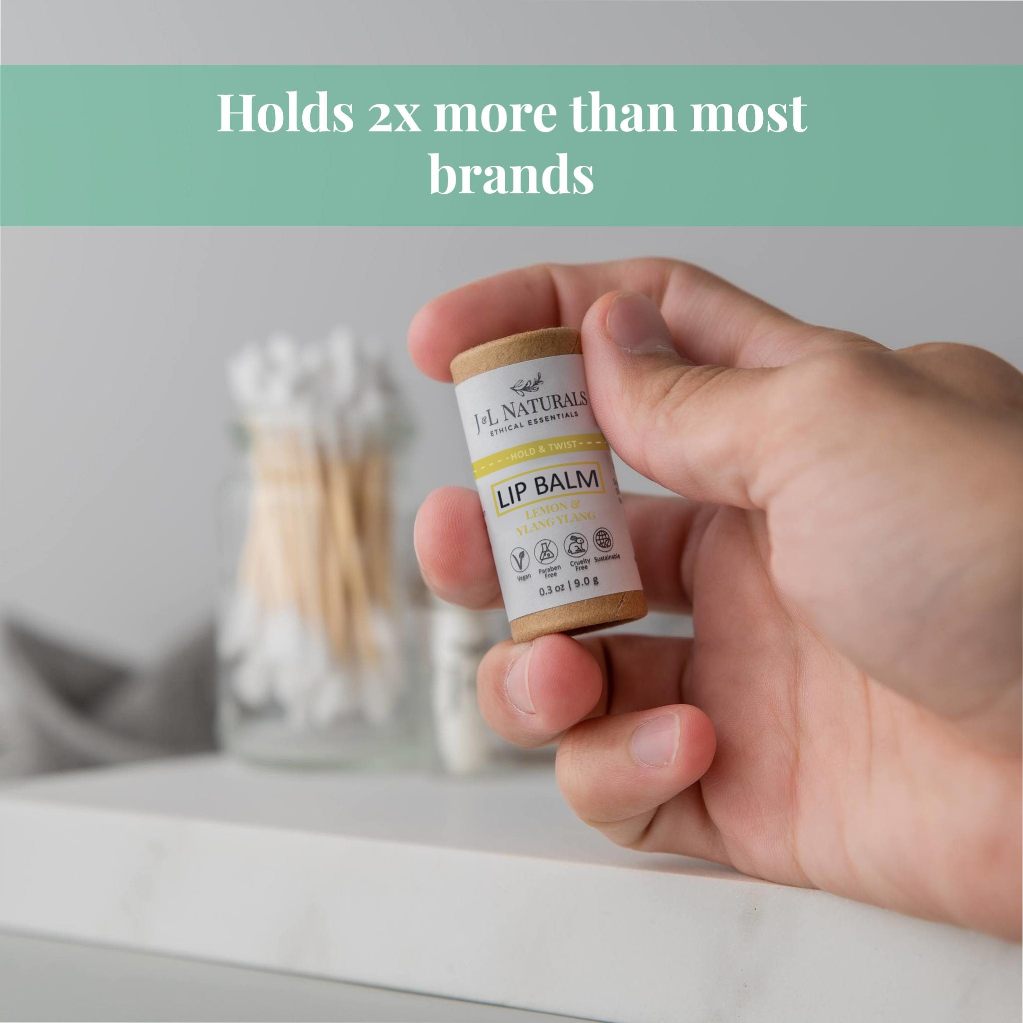 Lip balm tube, brown and white with J&L Naturals label, held in hand