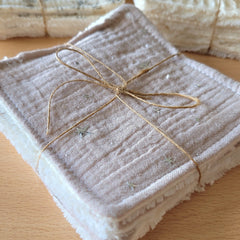 Close-up of soft bamboo and cotton wipes stacked in a neutral-toned reusable pouch, texture detail visible