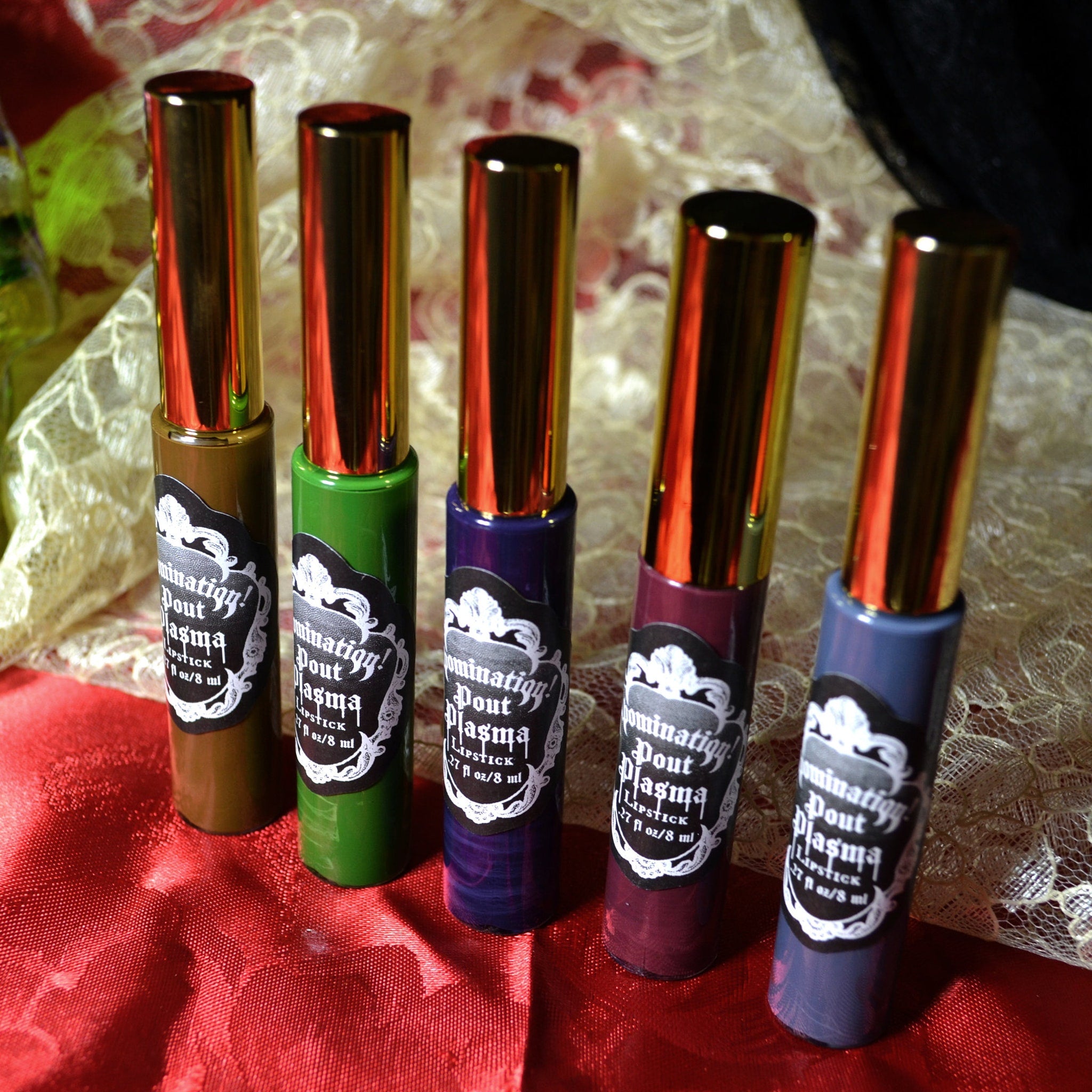 Lipstick tubes with gold caps, various colors, and "Dominatigy Pout Plasma" label displayed