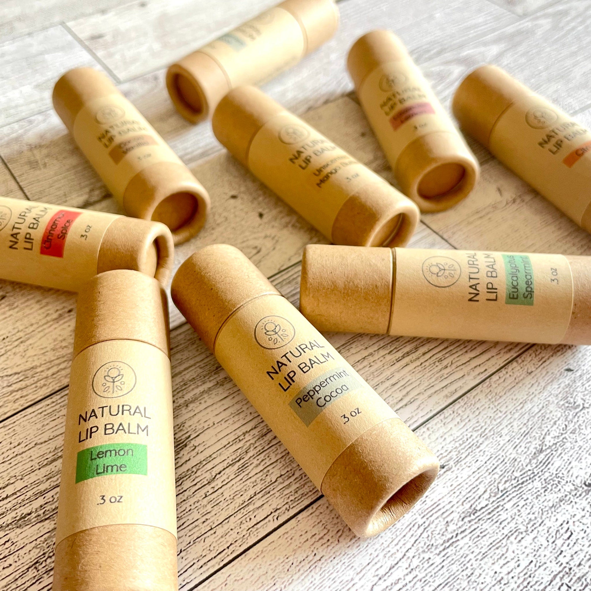 Lip balm tubes in tan cardboard with colored labels, Kind Home & Beauty Co branding visible