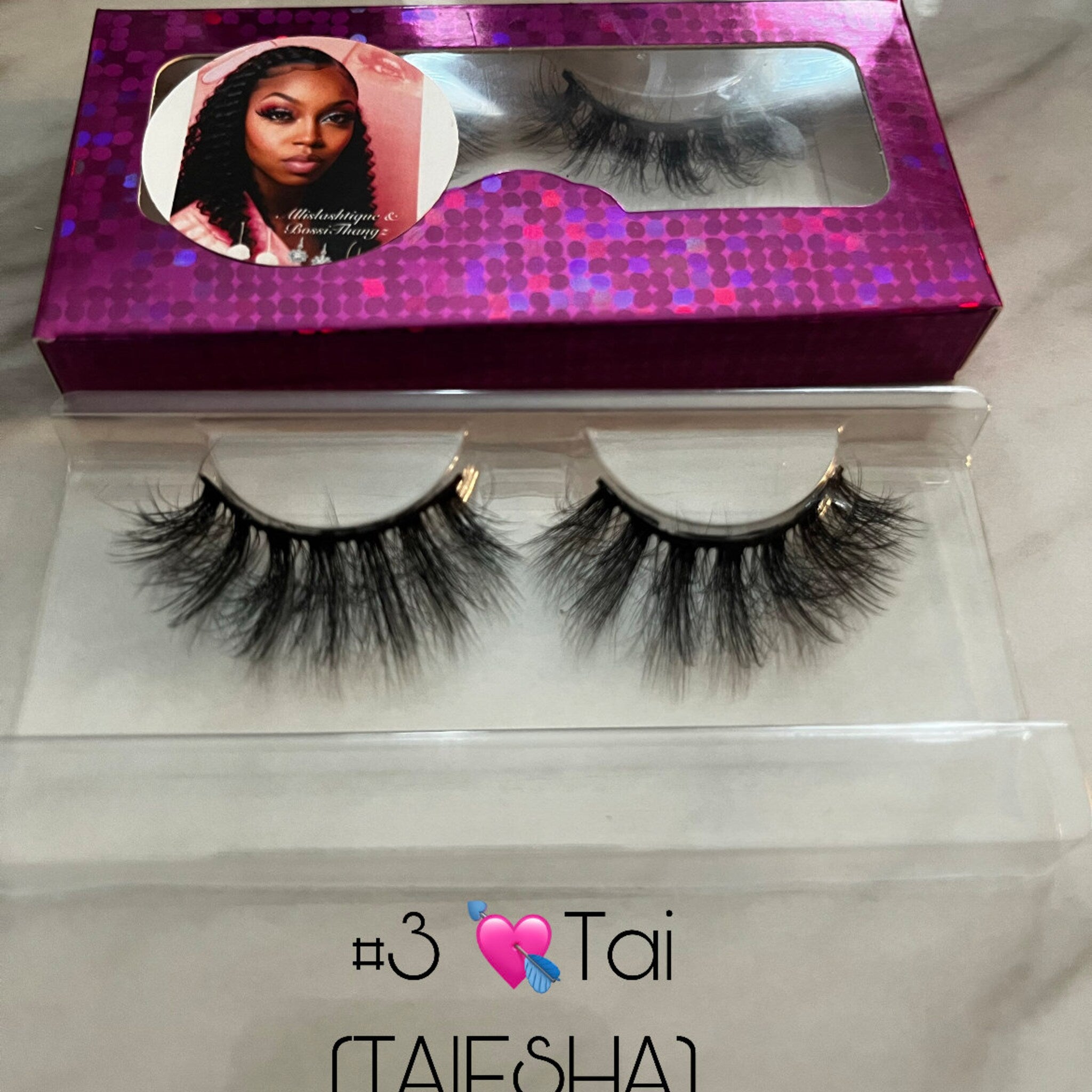 False eyelashes with black synthetic fibers in clear plastic packaging, with purple box and brand name visible