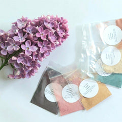 Close-up of six round vegan eyeshadow pans in earthy tones with matte and shimmer finishes, arranged neatly.