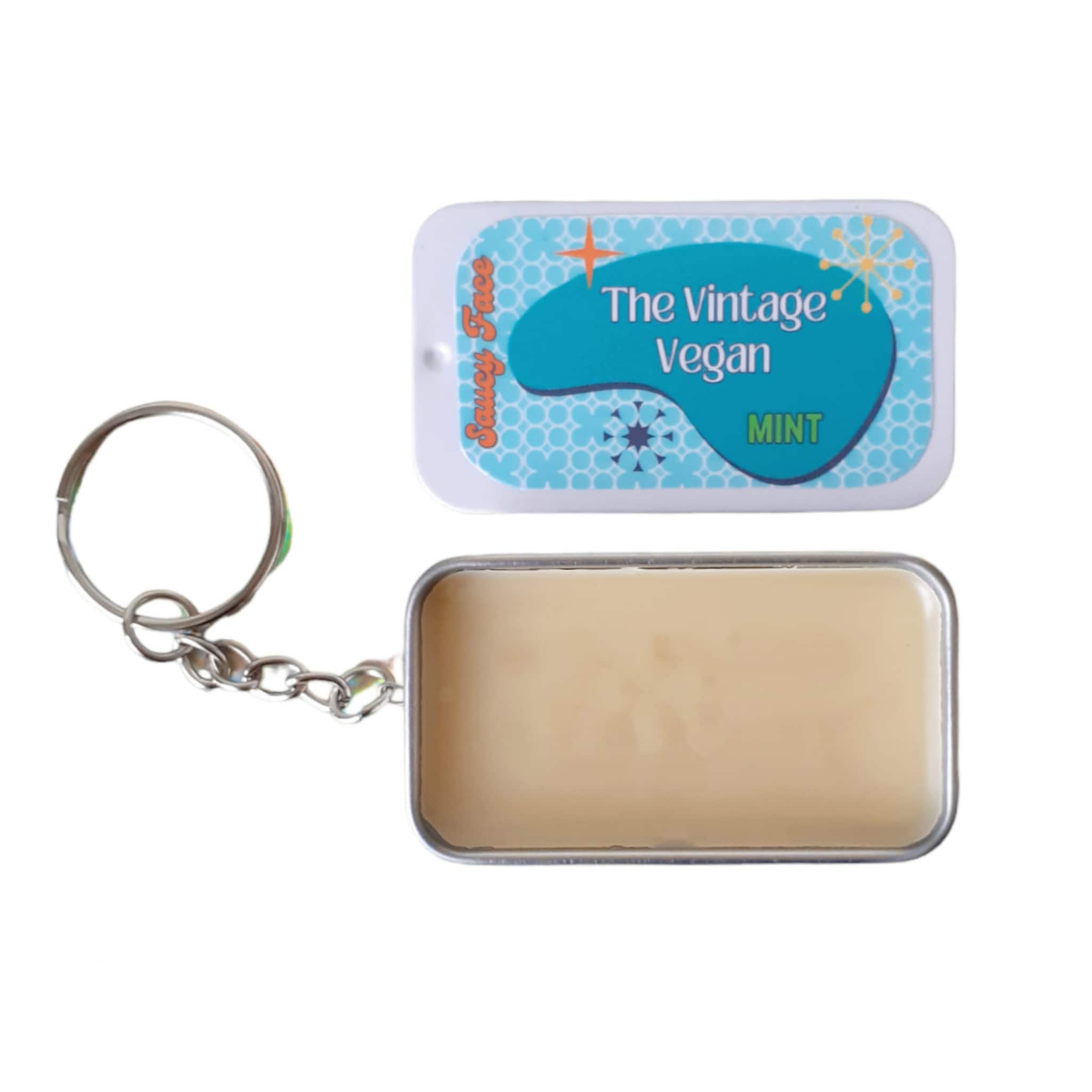 Lip balm tin with blue and white pattern, mint text, and Saucy Face brand
