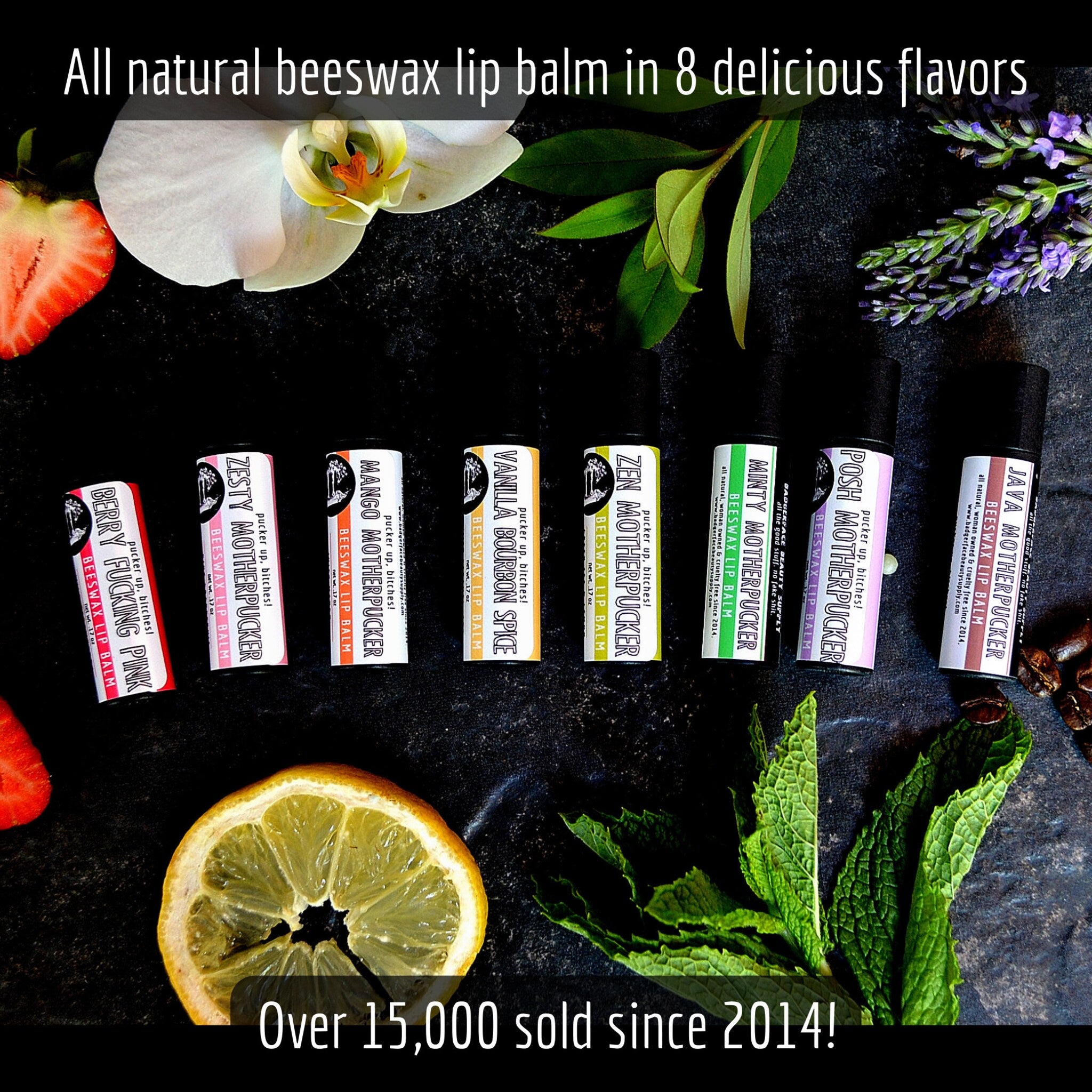 Beeswax lip balm tubes in various colors with "MOTHERPUCKER" brand text, surrounded by fruit and flowers