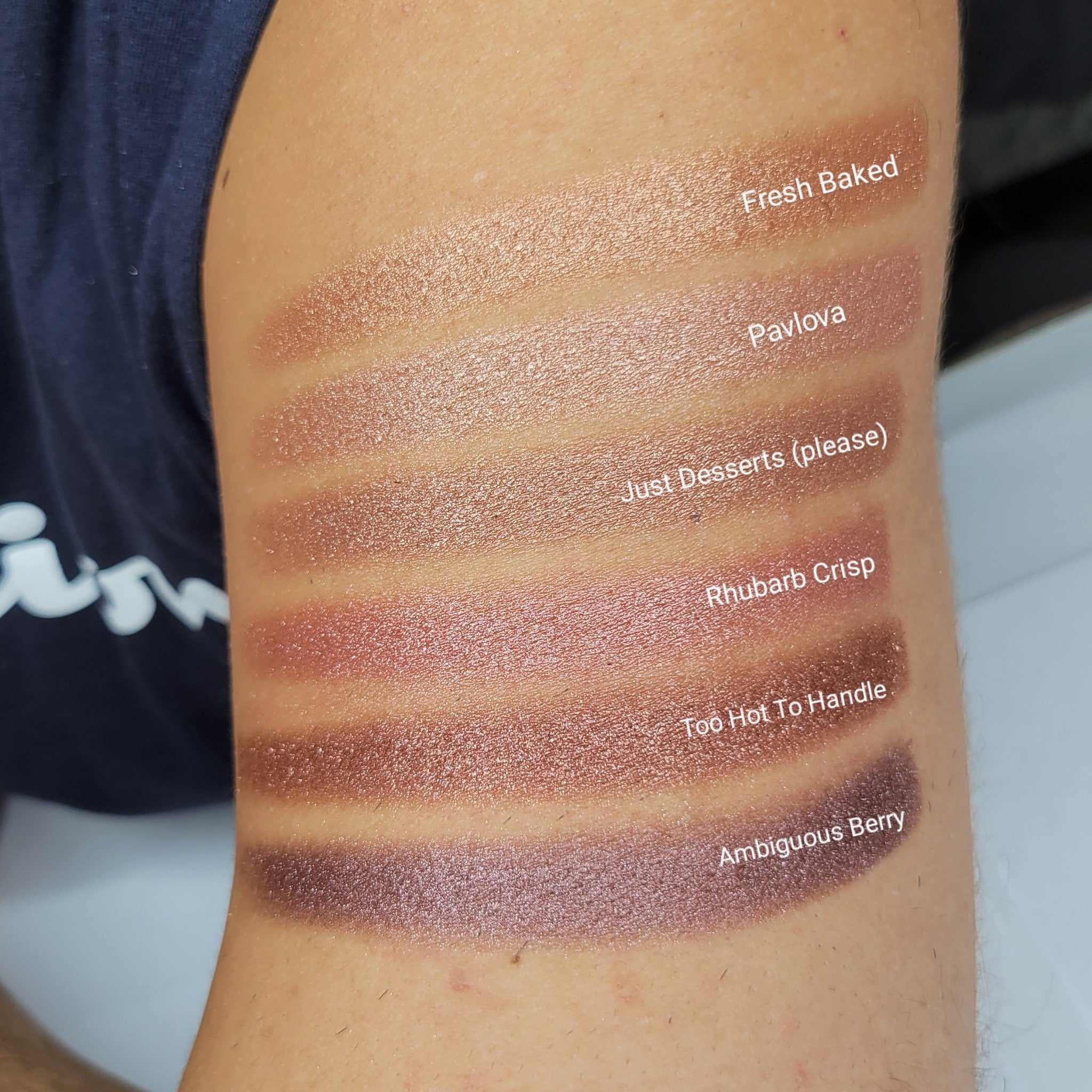 Close-up of a makeup brush applying beige shimmer eyeshadow to eyelid, showcasing soft blendable texture