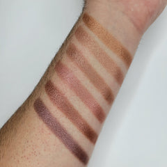 Side view of beige blush shimmer eyeshadow in round compact showing baked powder texture
