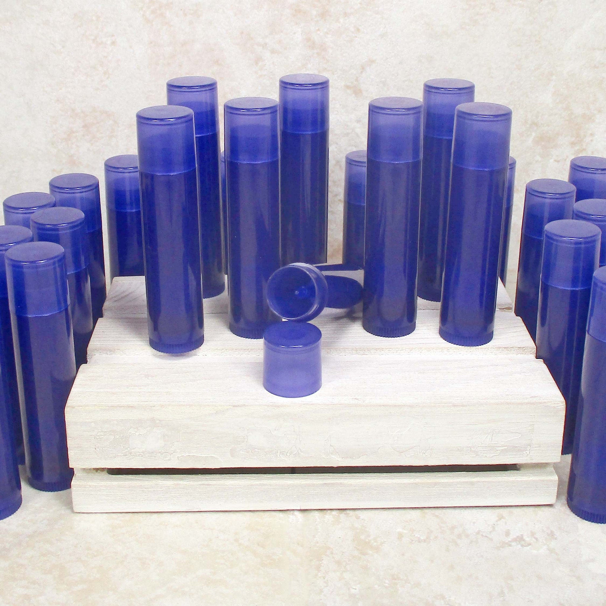 Lip balm tubes, blue plastic tubes, white wood crate, product display