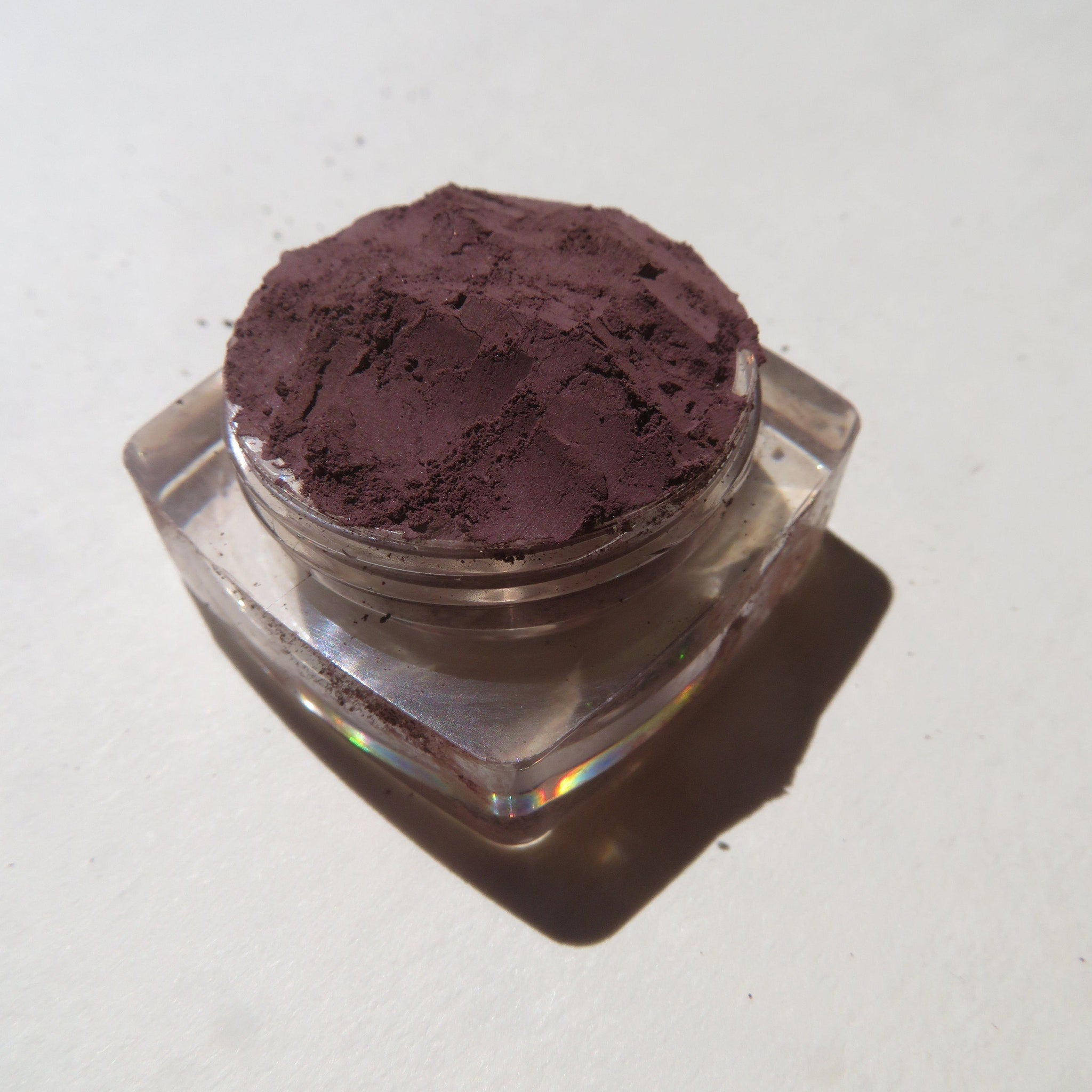 Close-up of super dark muted purple loose mineral eyeshadow pigment with matte finish