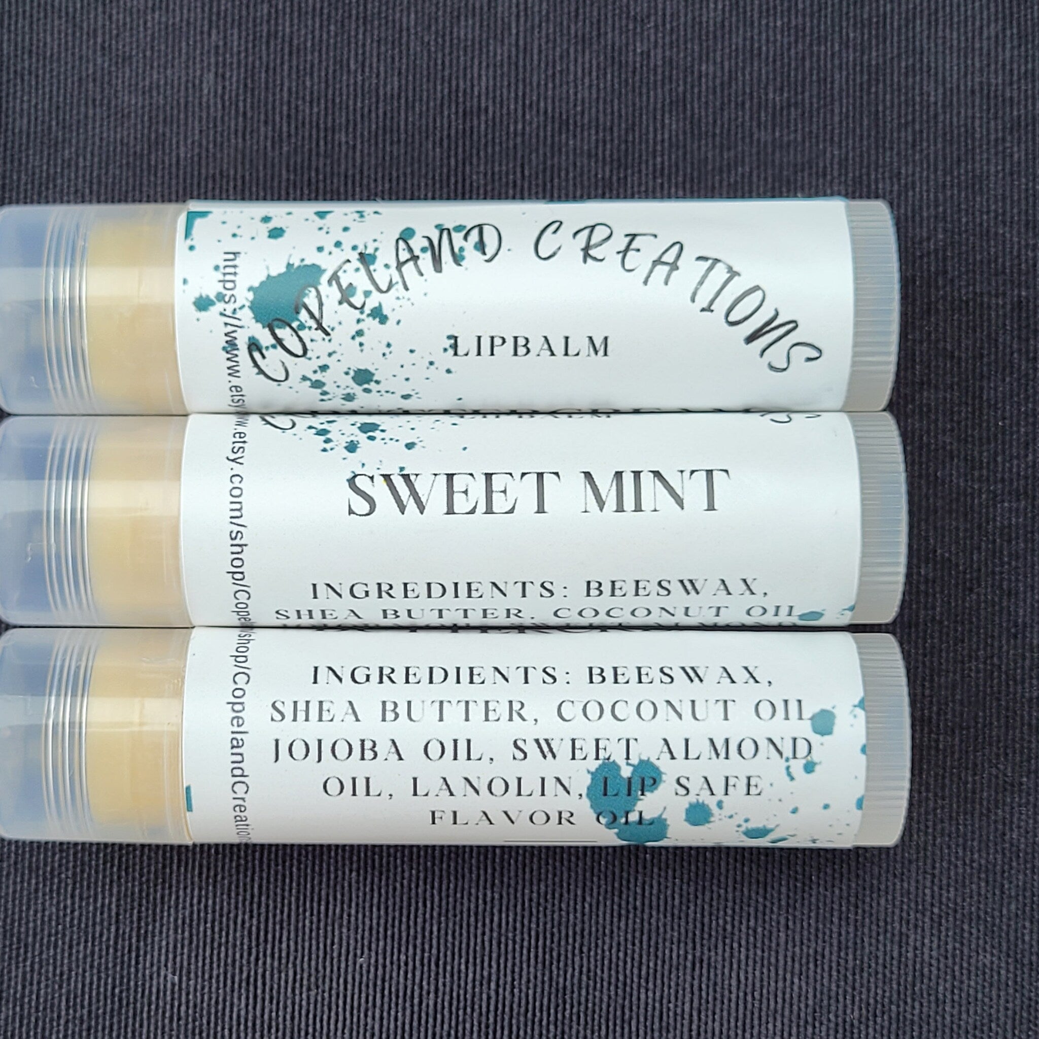 Lip balm tubes with white labels, teal accents, and Copeland Creations text