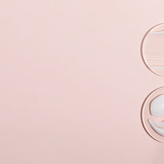 Skincare product samples on pink surface, transparent and white cream textures, circular shape