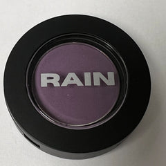 Close-up of matte amethyst purple eye shadow in a sleek black compact with silver detailing.