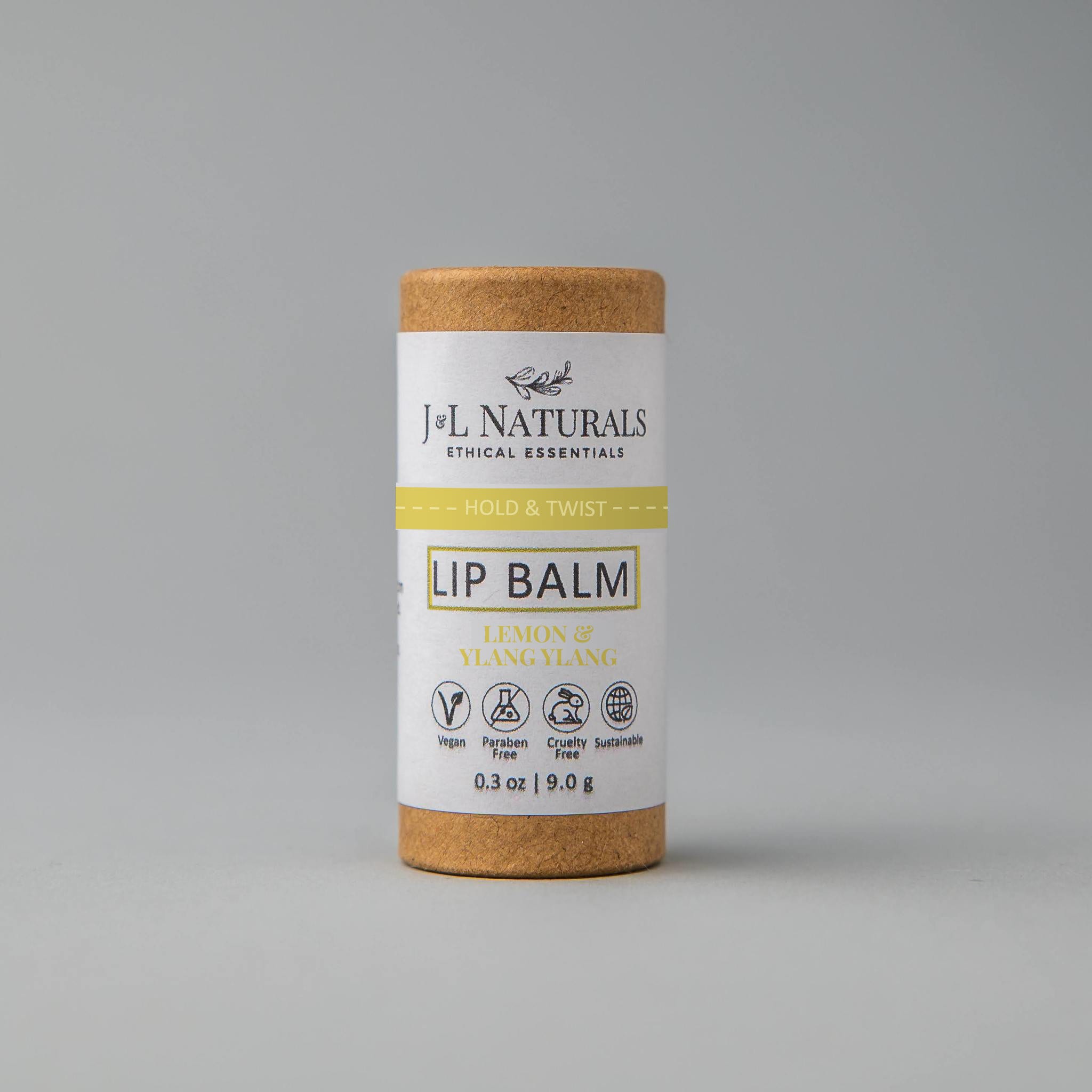 Lip balm tube in brown cardboard with white label, J&L Naturals branding and text