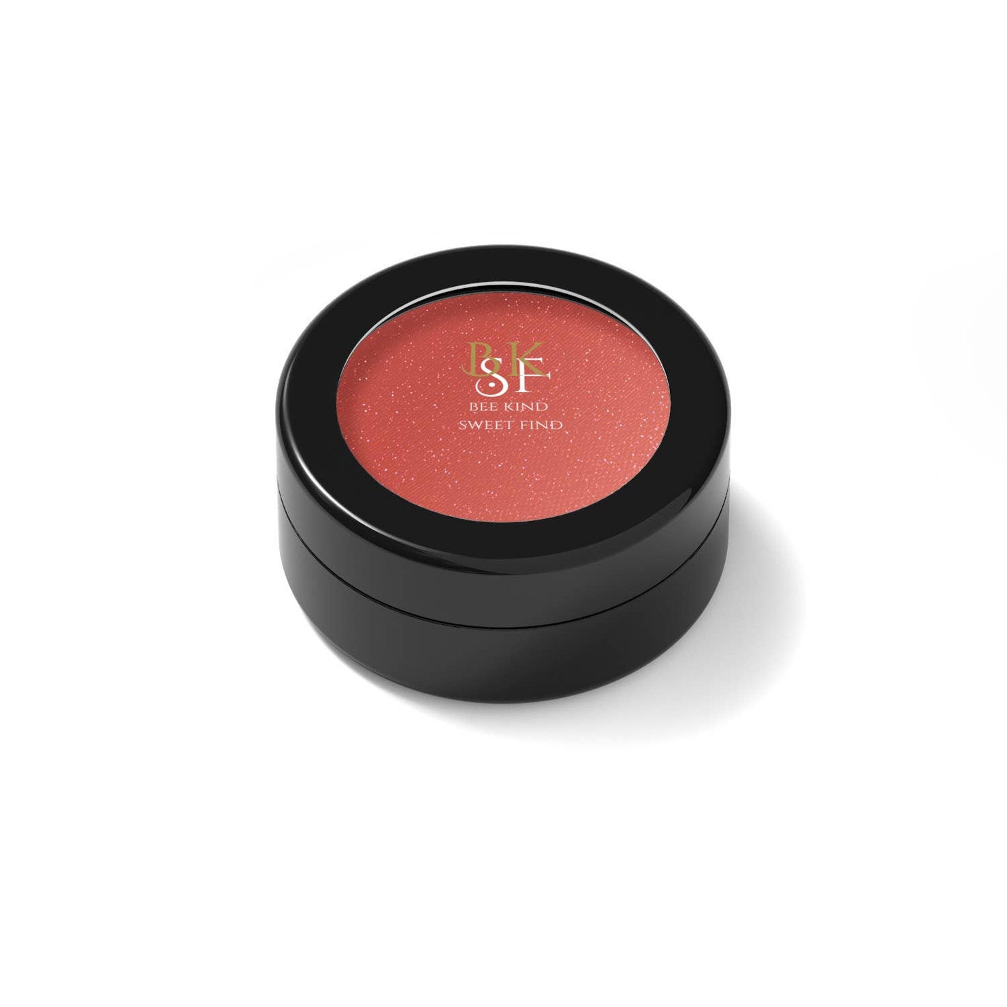 Close-up of BKSF Sparkle Eye Shadow pan showing shimmering bronze pigment with reflective flecks