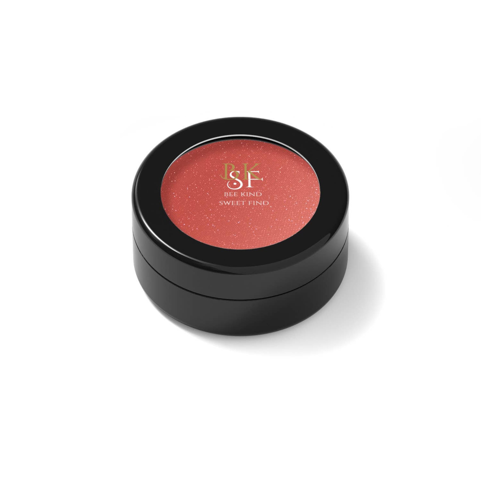 Blush compact with coral color, black container, and brand name text