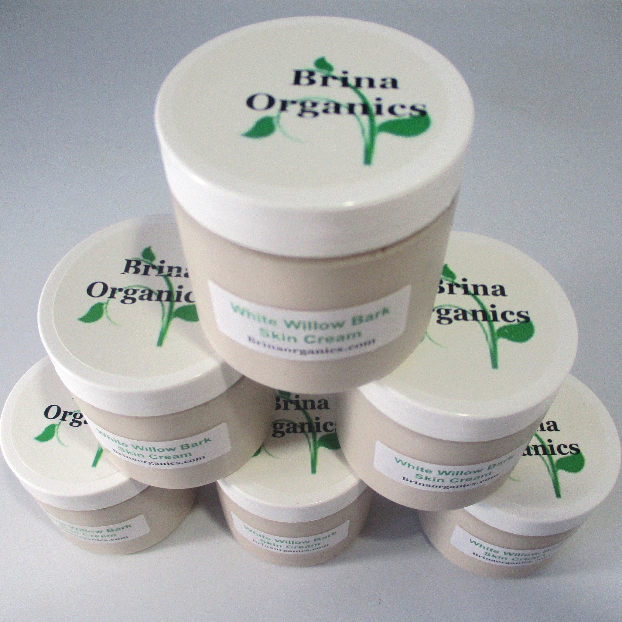 Skin cream jars, white lids, beige containers, Brina Organics branding visible on top