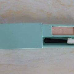 Eyeshadow compact in pale pink and teal, with applicator, open showing product