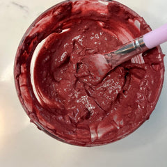 Face mask in glass bowl with red color and pink spatula, for application