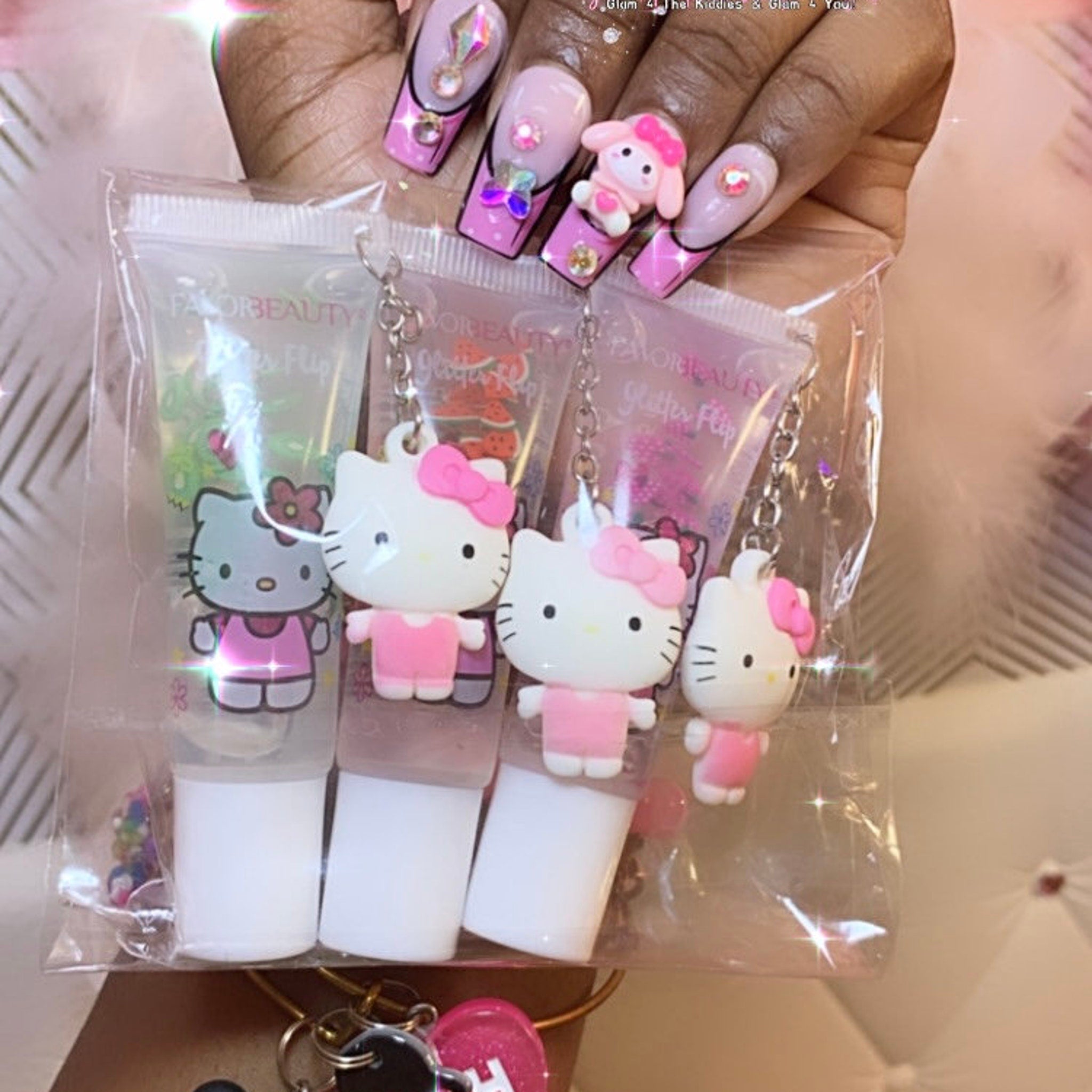 Lip gloss set with Hello Kitty charms, pink and white, clear plastic packaging, Favor Beauty brand