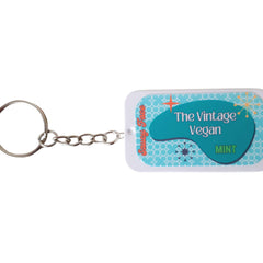 Mint lip balm with teal and white design, "The Vintage Vegan" text, and metal keychain
