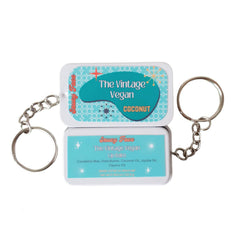 Lip balm tin with teal and white pattern, key ring, and Saucy Face brand text