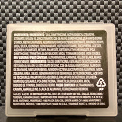 Close-up of mineral coal eye shadow pan showing rich black matte texture with smooth, pigmented finish