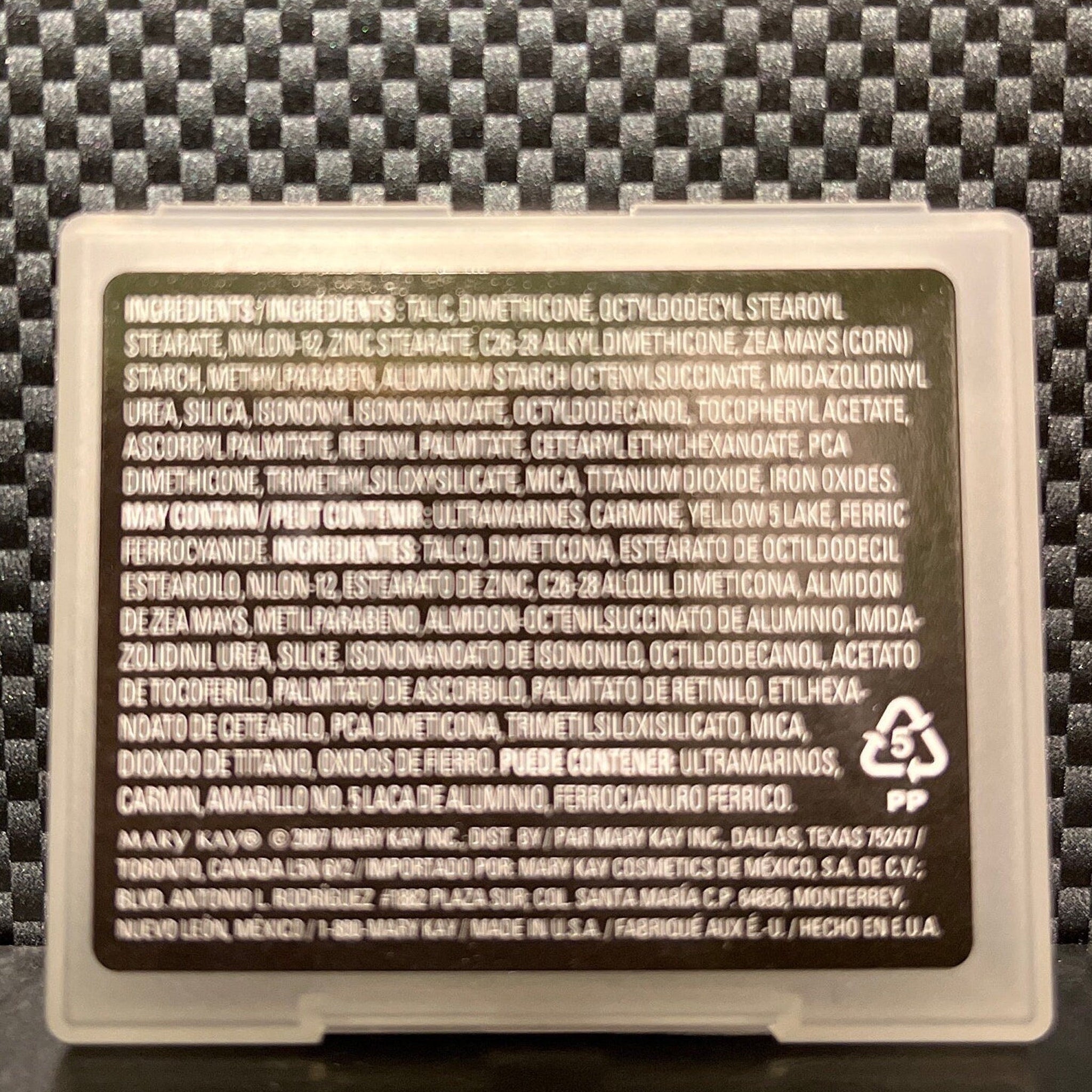 Close-up of rich espresso mineral eye shadow with smooth, pigmented powder texture in compact case