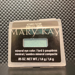 Close-up of a makeup brush applying shimmering azure mineral eye shadow to eyelid